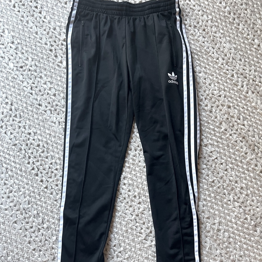 Adidas track pants with size zippers.